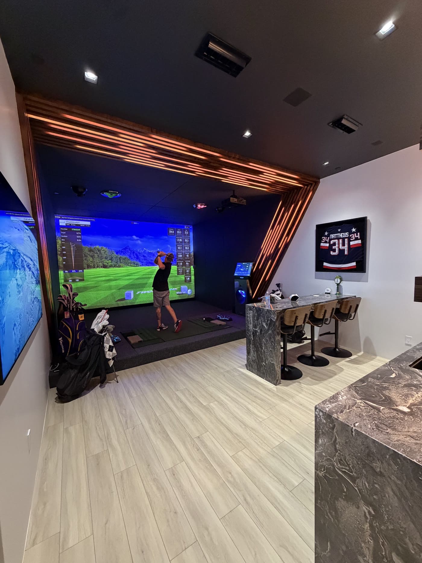 The Golfzon simulator bay in the showroom, the hitting mats and kiosk in frame